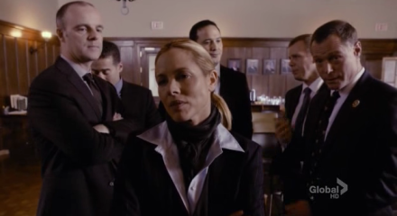Jane Timoney (Maria Bello) surrounded by her ensemble of sexist, bullying cops.